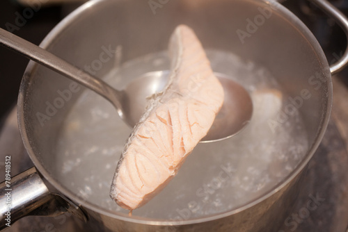A fillet of salmon being poached on a stove