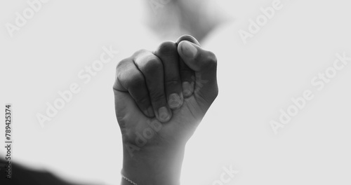 Close-up fist in the air symbolizing empowerement. African American woman raises hand in the air claiming independence and solidarity in black and white