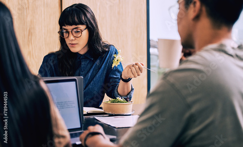 Business woman, computer and eating while working in a coworking office in a break room. Startup, salad and professional with web design project and internet research with lunch at company with food