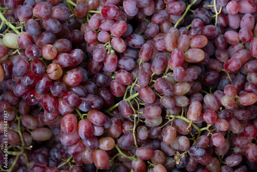 Bunches of red grapes in a supermarket, market stall or greengrocer. Full-screen background image Bunches of red grapes in a supermarket, market stall or greengrocer. Full-screen background image