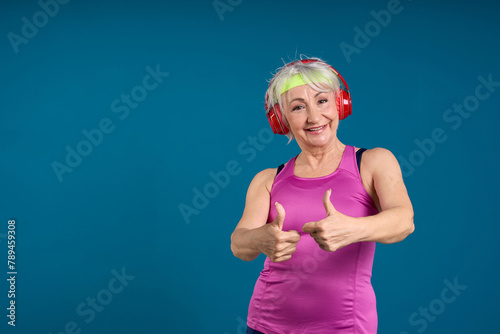 Happy Senior Giving Thumbs Up with Headphones