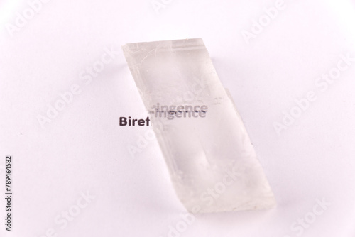 Optical birefringence demonstrated using a text using a natural double spar / calcite crystal