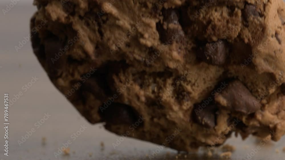 Slow-motion Video of Chocolate Chip Cookie Falling and Crumbs Dispersion at 800 fps, Impacting Table Surface Slow-motion Video of Chocolate Chip Cookie Falling and Crumbs Dispersion at 800 fps, Impacting Table Surface