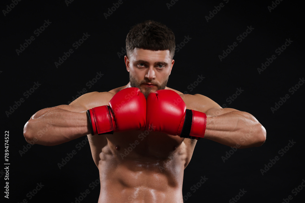 Man in boxing gloves on black background
