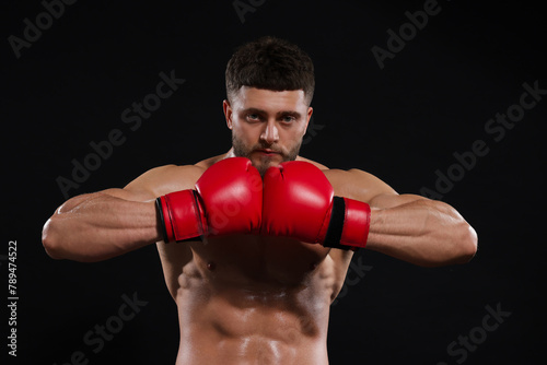 Man in boxing gloves on black background