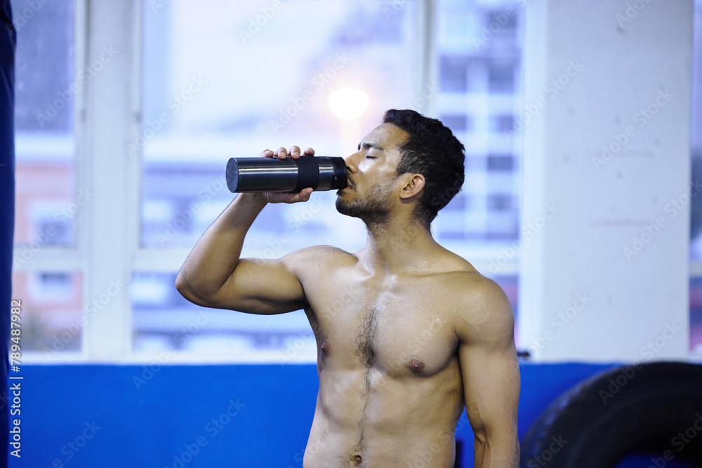Man, athlete and drinking water at gym, nutrition and hydration after workout or strength training. Male person, detox and mineral liquid for recovery after exercise, fitness and boxer or shirtless Man, athlete and drinking water at gym, nutrition and hydration after workout or strength training. Male person, detox and mineral liquid for recovery after exercise, fitness and boxer or shirtless