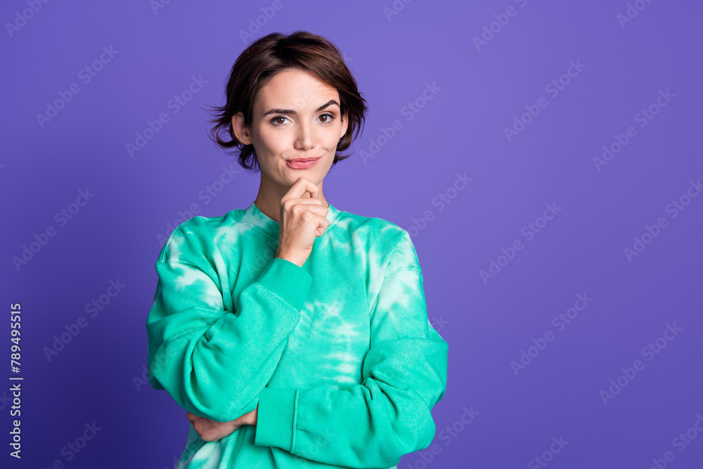 Naklejka premium Photo portrait of attractive young woman touch chin thoughtful dressed stylish green clothes isolated on violet color background