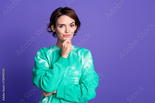 Photo portrait of attractive young woman touch chin thoughtful dressed stylish green clothes isolated on violet color background