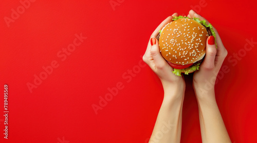 hands holding burger on red background. fast food concept for advertising and menu design restaurant © Rangga Bimantara