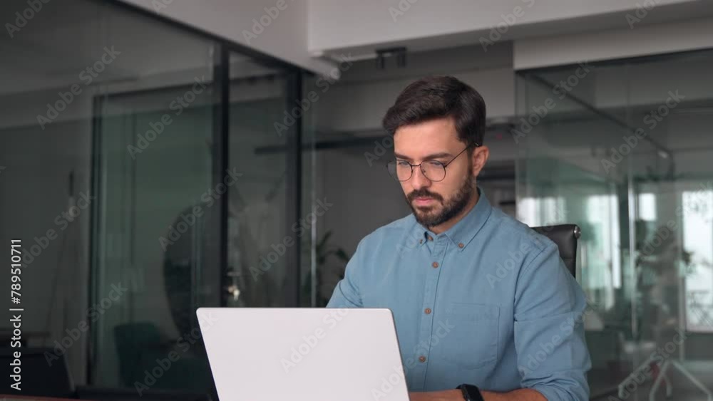 Busy professional business man company employee, young male worker software developer, latin businessman typing on computer technology using laptop searching on web working at office workplace desk.
