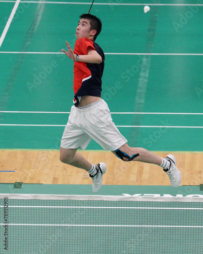 A powerful badminton player plays single badminton