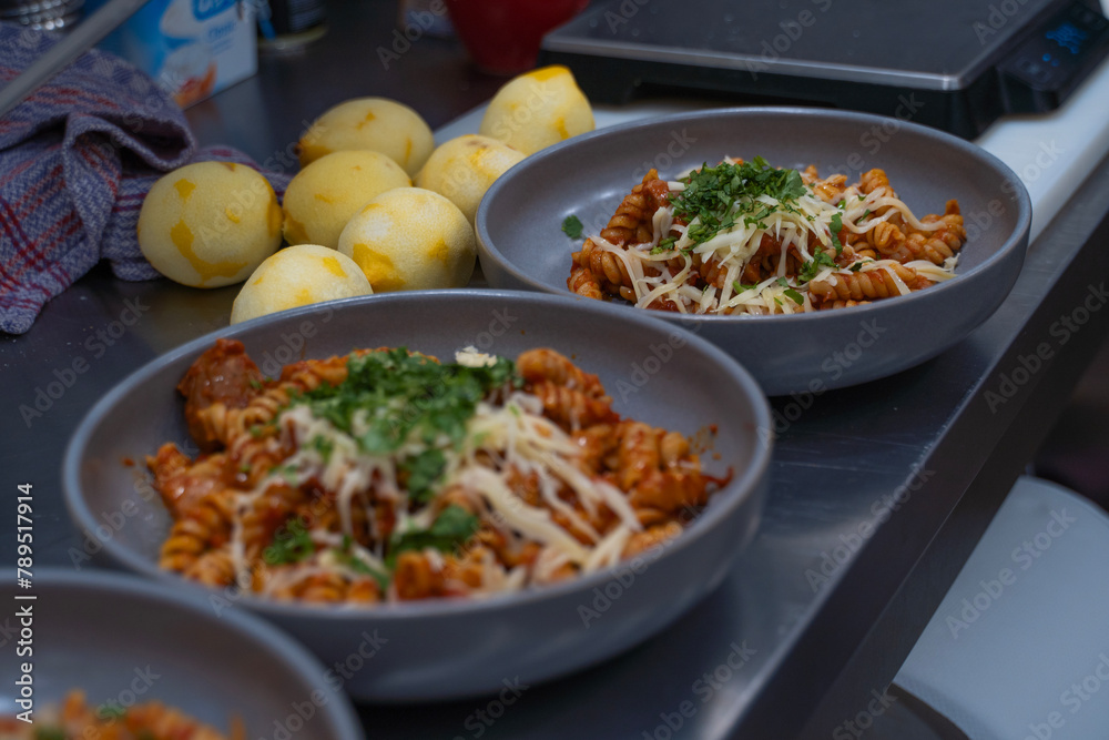 A grey plate with macaroni, cheese and herbs. Homemade food. Supper. High quality photo