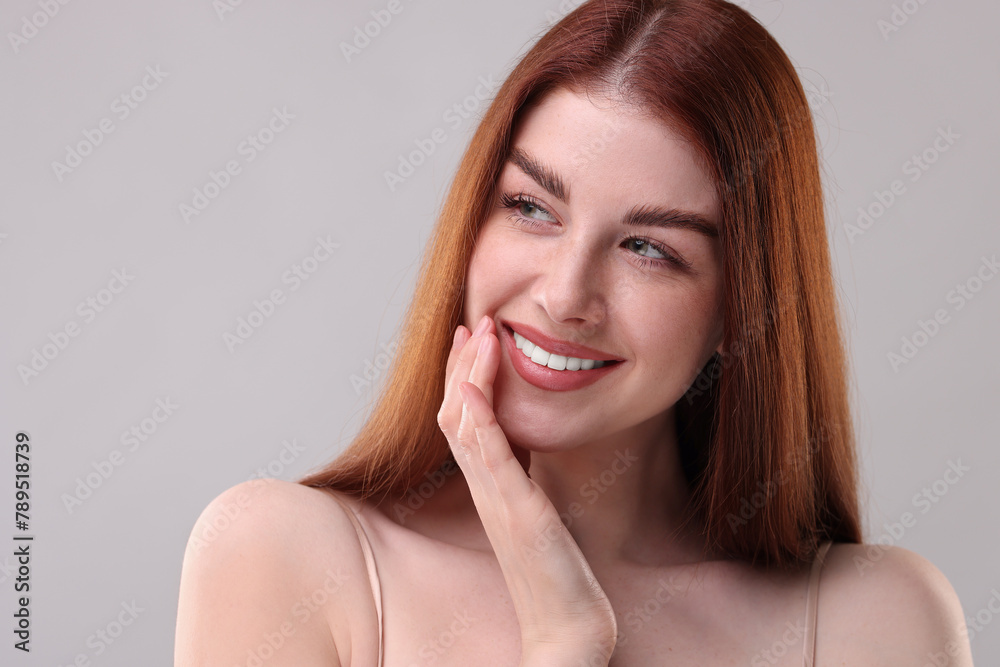 Portrait of smiling woman on grey background, closeup Portrait of smiling woman on grey background, closeup
