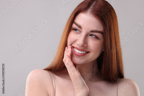 Portrait of smiling woman on grey background  closeup