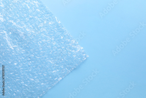 Transparent bubble wrap on light blue background, top view. Space for text © New Africa