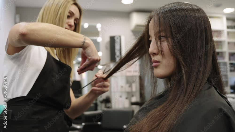 Hairdresser trimming the hair of a chinese woman Hairdresser trimming the hair of a chinese woman