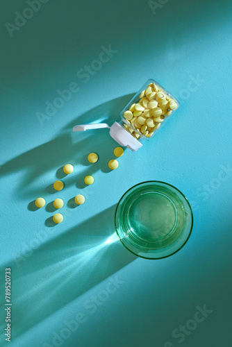 Pills and a glass of water aas medical concept with sunlight backround photo
