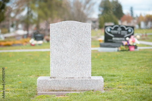 A large blank tombstone in a cemetery.  photo