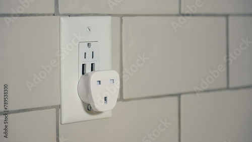 A closeup view of a European grounded plug-in electrical outlet power converter. This adapts a type G plug from the United Kingdon, UK, Singapore, Malaysia, UAE, Ireland, and Hong Kong to the USA. photo
