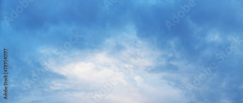 The sky covered with thick blue clouds with a gleam in the middle