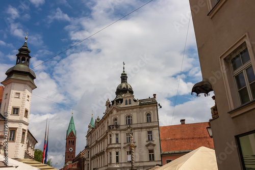 Vibrant atmosphere of street cafes on Grajski Trg or Castle Square. View of Maribor Castle and Regional Museum offering rich history. Grandeur of St. Florian Column, symbol of Maribors resilience. photo