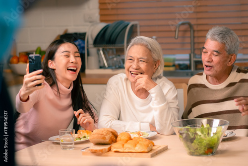 Family Togetherness in the Kitchen  Asian Mother Prepares a Happy Dinner  Joined by Father  Daughter  and Senior Elderly  Creating Fun and Memorable Meals  A Heartwarming Holiday Gathering