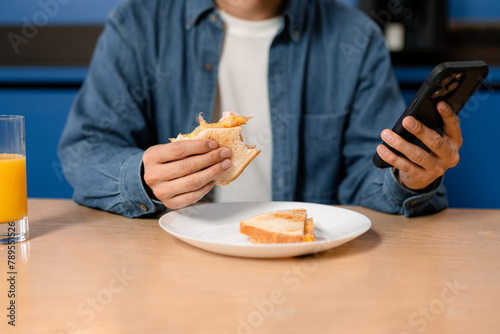 A man eats sitting in the kitchen