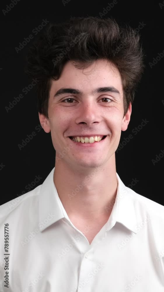 Portrait of a smiling young Caucasian man or office worker, over black background. Businessperson with positive emotion. Vertical video. Portrait of a smiling young Caucasian man or office worker, over black background. Businessperson with positive emotion. Vertical video.