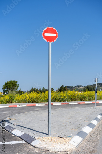 No-entry traffic sign stands prominently against the springtime landscape of Israel, symbolizing road restrictions with natural beauty behind.