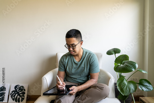 A Gen Z digital aritst illustrating on an iPad in their home office photo