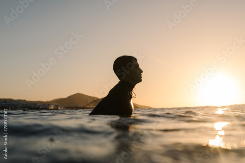 The serene silhouette of a surfer peacefully floating photo