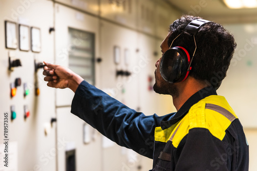 Marine engineer during his daily routine work in engine room. Seafarers life.