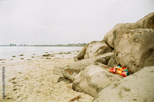 Wintery beach with bright towel left in creviche photo
