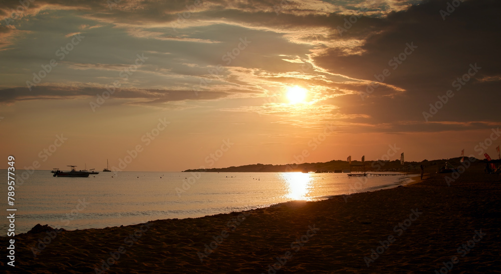 Panorama of a beautiful peaceful bay with boats on the west coast on a sandy Corfu beach at sunset time Panorama of a beautiful peaceful bay with boats on the west coast on a sandy Corfu beach at sunset time