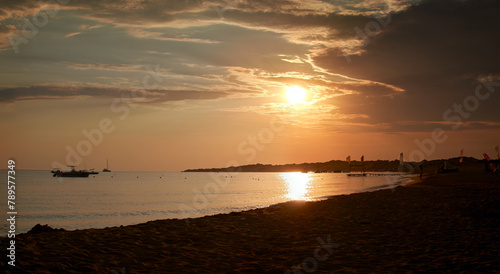 Panorama of a beautiful peaceful bay with boats on the west coast on a sandy Corfu beach at sunset time