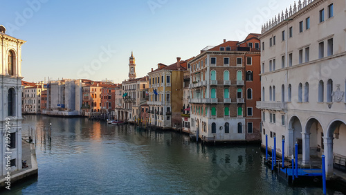 Scenic sunset view of Grand Canal in city of Venice, Veneto, Italy, Europe. Famous landmarks along  ater traffic corridor Grand Canale. Urban tourism in summer. Soft light shining on historic building photo