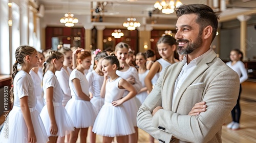 A man stands in front of a group of young girls in white tutus