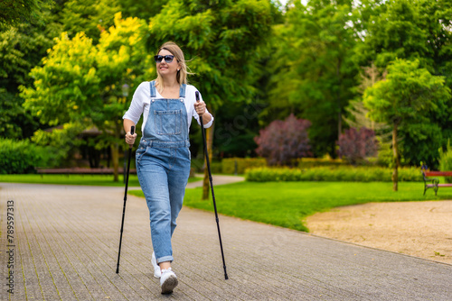 Nordic walking - woman exercising in city park
