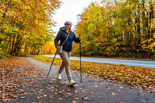 Mid-adult woman exercising nordic walking in city park
