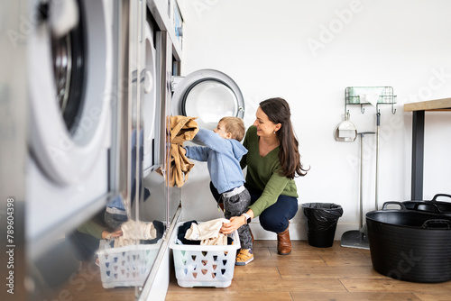 Mother and little boy doing laundry photo