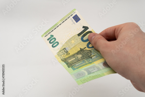 Man holding 100 EUR banknote paper currency Euro isolated on white background