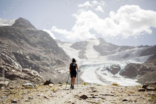 trekker girl on snowy mountain walking to the glacier. photo