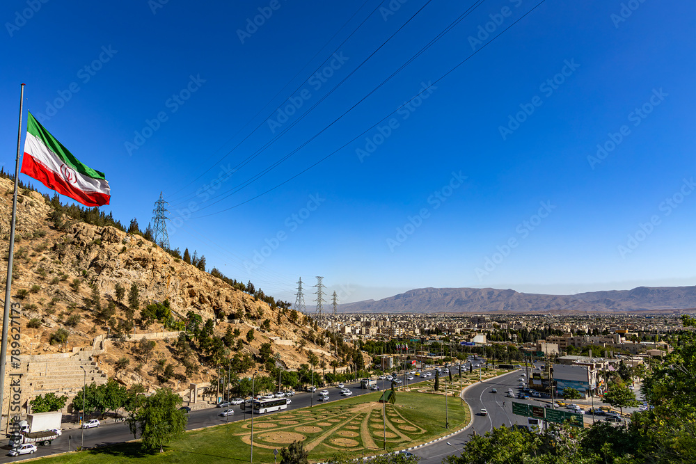 Iran. Shiraz. Cityscape from Quran Gate (also known as Shiraz Gate, located at the northeastern entrance of the city). There is the national flag of Iran fluttering in the wind