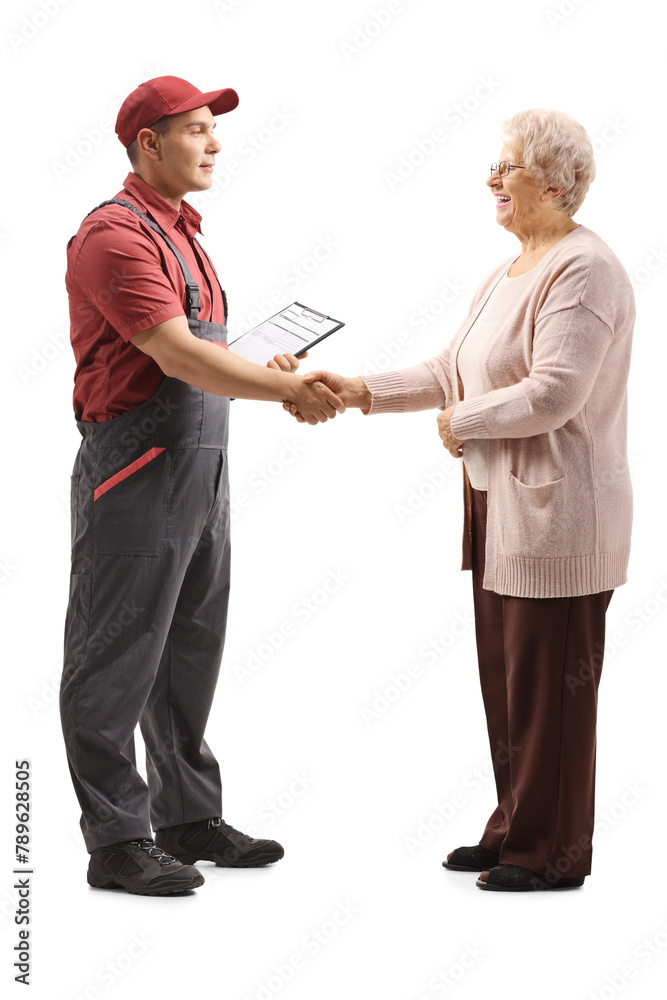 Full length profile shot of repairman and an elderly woman shaking hands Full length profile shot of repairman and an elderly woman shaking hands