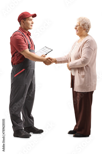 Full length profile shot of repairman and an elderly woman shaking hands photo