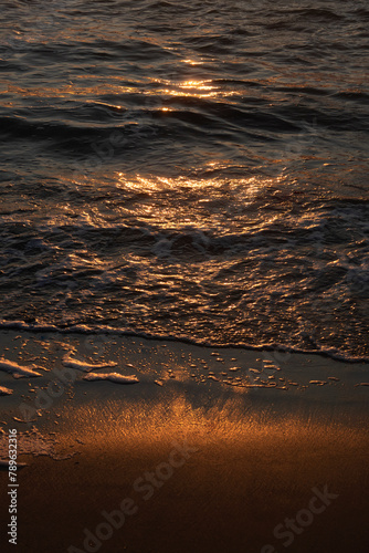 Dark sea water and sand at sunset background photo