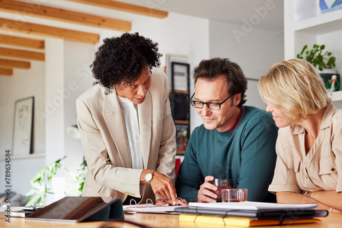 Financial advisor showing investment to couple at home photo
