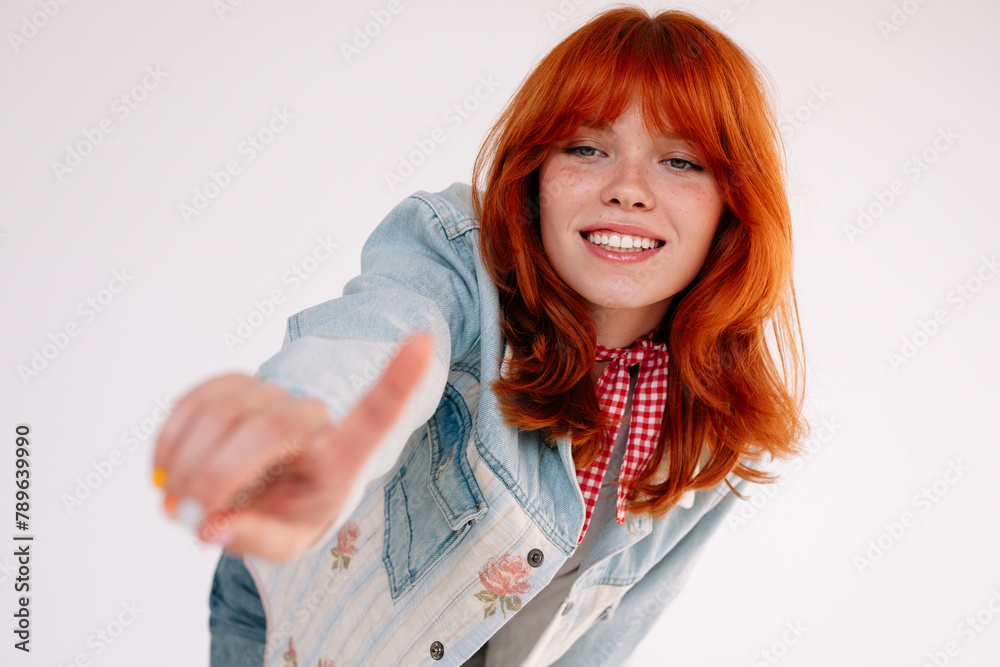 Cheerful redhead girl pointing at camera Cheerful redhead girl pointing at camera