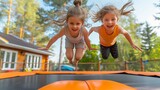 Two toddlers have fun jumping on a trampoline under the sky, smiling and happy