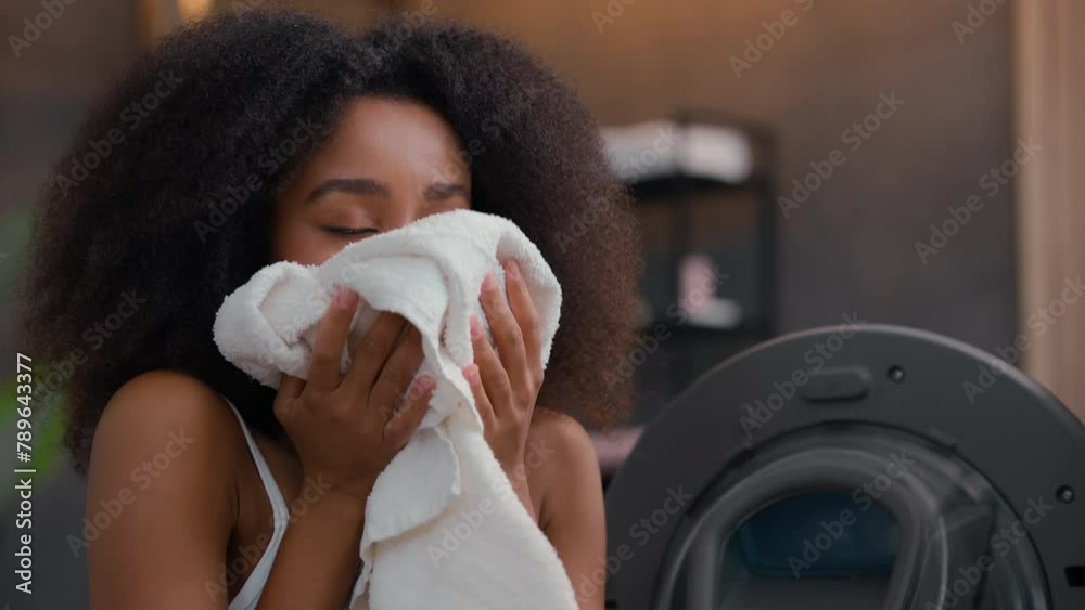 African American female woman girl ethnic lady housewife homeowner housework open washing machine smell clean white towel cloth good pleasant fresh smelling sniff aroma laundry conditioner gel smiling